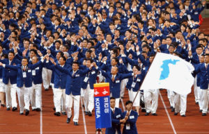 FILE - In this Sept. 29, 2002 file photo, athletes from North and South Korea march together, led by a unification flag during opening ceremonies for the 14th Asian Games in Busan, South Korea. Seven months ahead of the Pyeongchang Olympics, many in South Korea, including new liberal President Moon Jae-in, hope to use the Games as a venue to promote peace with rival North Korea. To do so, the North's participation is essential, but an ongoing nuclear tension and a lack of winter sports athletes in North Korea could ruin the attempts at reconciliation. (Yonhap via AP, File)