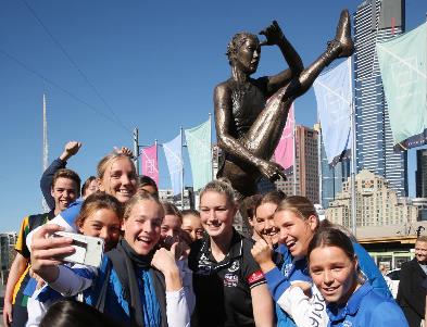 A group of people standing in front of a crowd posing for the camera Description automatically generated