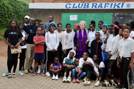 A group of people standing in front of a crowd posing for the camera Description automatically generated